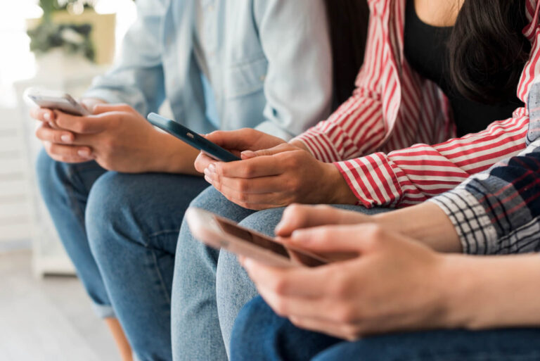 Closeup of hands holding mobile phones wondering how to get sure clients on instagram