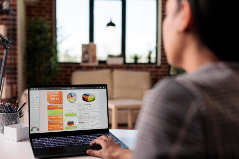 Office worker analyzing business charts on laptop